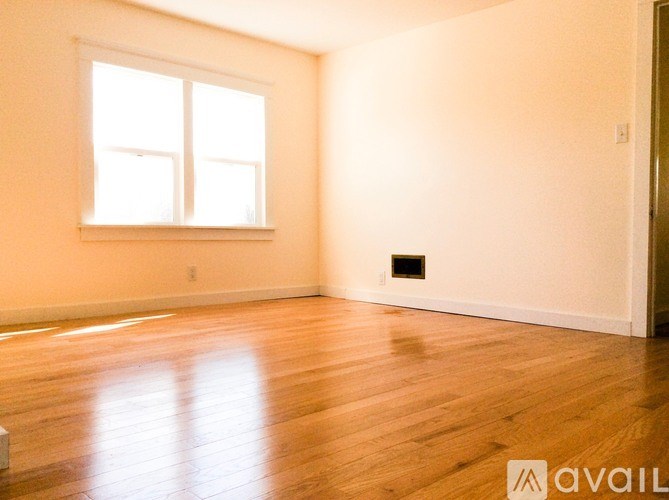 A room with a window and wooden flooring.