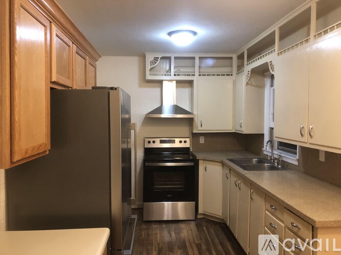 A kitchen with a black refrigerator and stainless steel appliances.