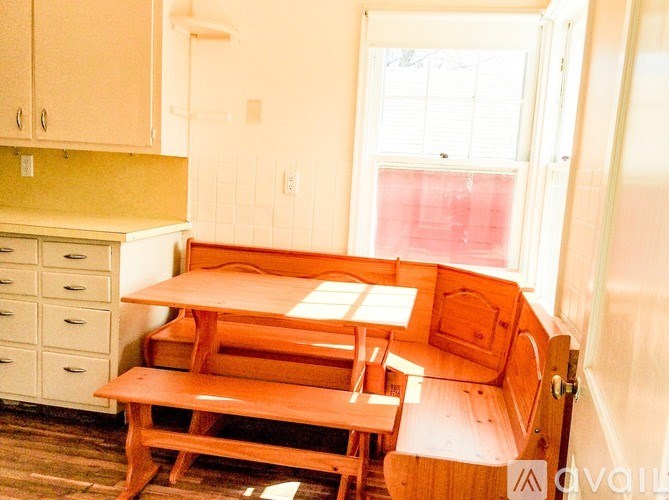 A kitchen with a table and chairs in front of a window.