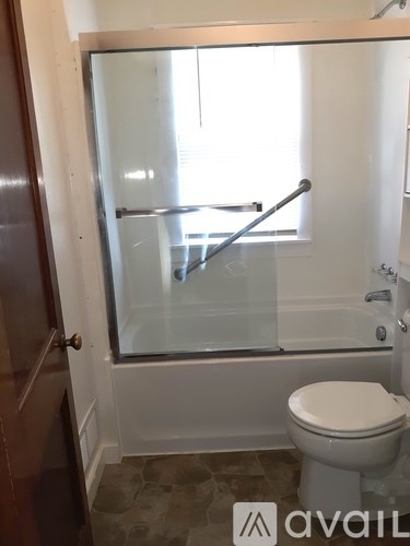 A bathroom with a toilet and a glass shower door.