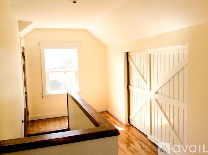 A room with a window and a wooden floor.