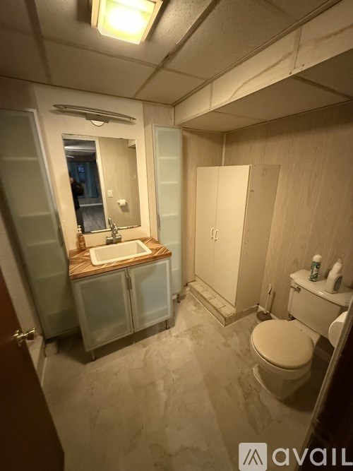 A bathroom with a toilet, sink, and medicine cabinet.