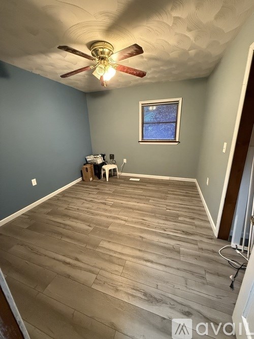 A room with a ceiling fan and a window.