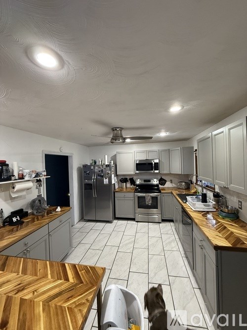 A kitchen with a wooden table and a dog.