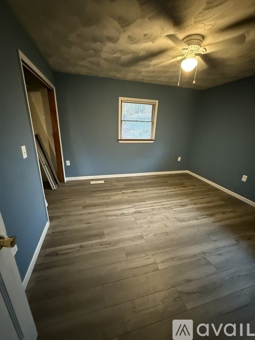 A room with wooden flooring and a window.