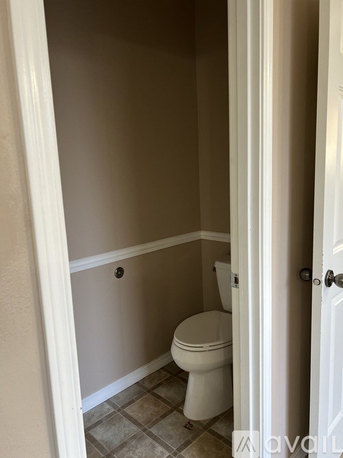 A white toilet in a small bathroom.