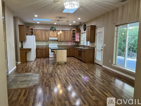 A spacious kitchen with wooden flooring and a central island.