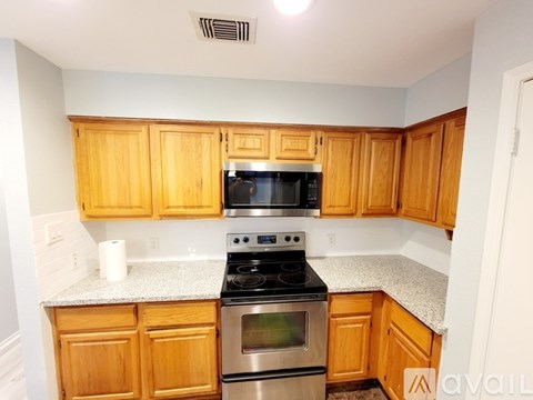 A kitchen with wooden cabinets and a granite countertop.