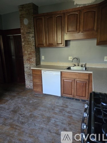 A kitchen with brown cabinets and a white dishwasher.