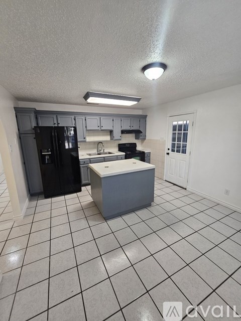 A kitchen with black appliances and white cabinets.