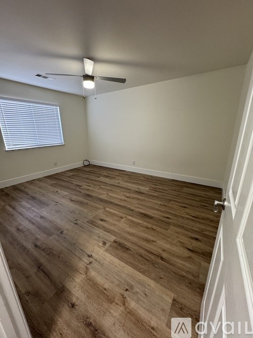 A room with wooden flooring and a ceiling fan.