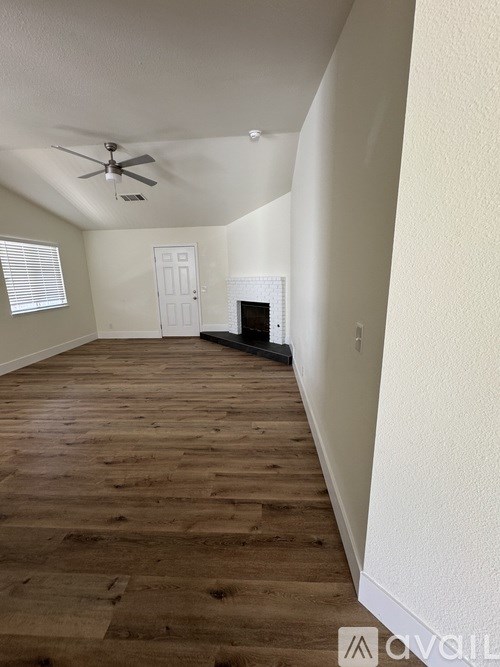 A room with wooden flooring and a ceiling fan.