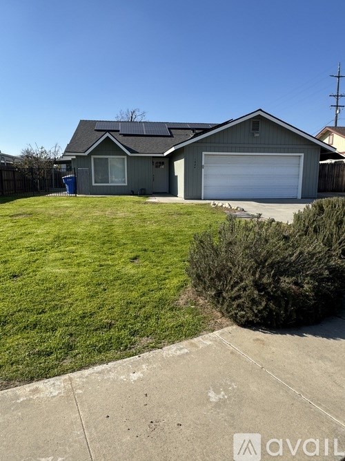A house with a grey roof and a white garage door is for sale.