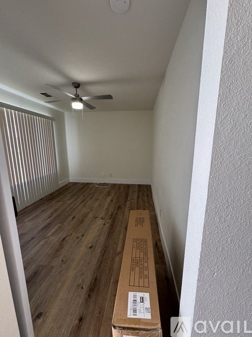 A room with a wooden floor and a ceiling fan.