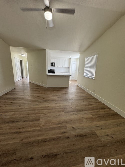 A room with wooden flooring and a ceiling fan.