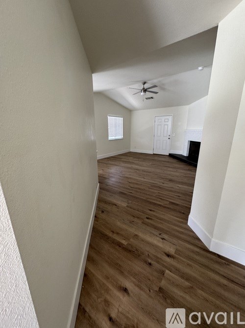 A room with wooden flooring and a ceiling fan.