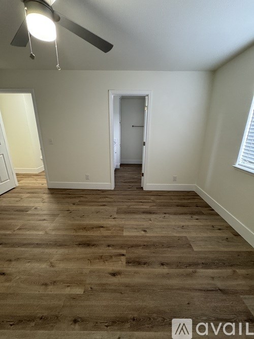A room with wooden flooring and a ceiling fan.