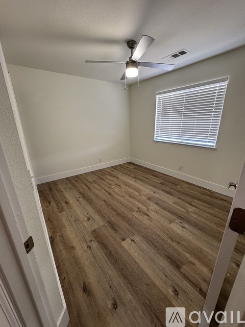 A room with wooden flooring and a ceiling fan.