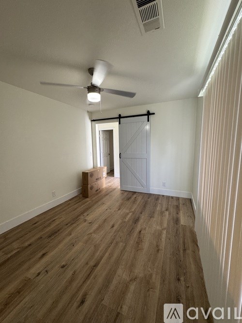 A room with wooden flooring and a ceiling fan.