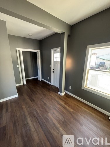 A room with wooden floors and grey walls.