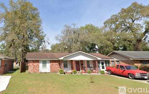 A red pickup truck is parked in front of a house.