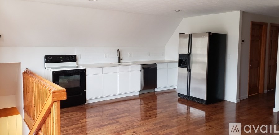 A kitchen with black appliances and white cabinets.