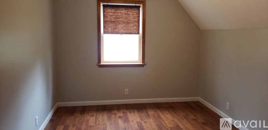 A room with a window and wooden floors is available.