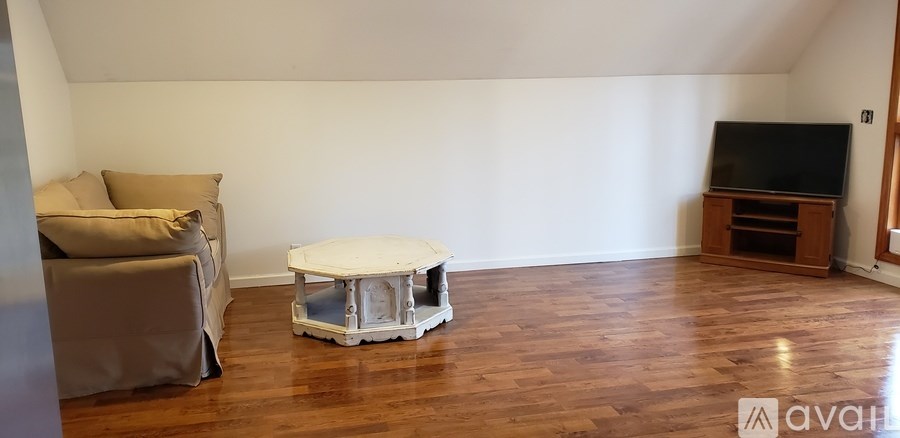 A living room with a grey sofa, a white coffee table, and a wooden entertainment center.