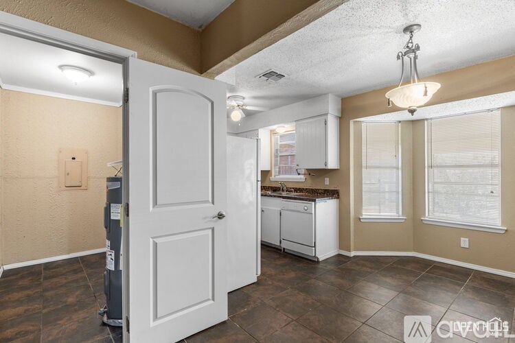 A kitchen with a white door and brown cabinets.