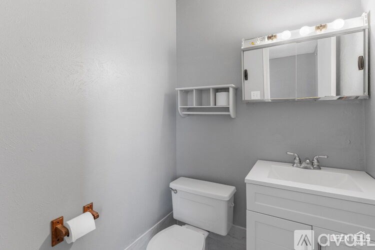 A white toilet and sink in a bathroom.