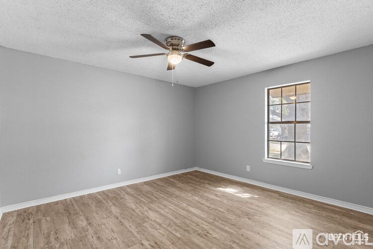 A room with a ceiling fan and a window.