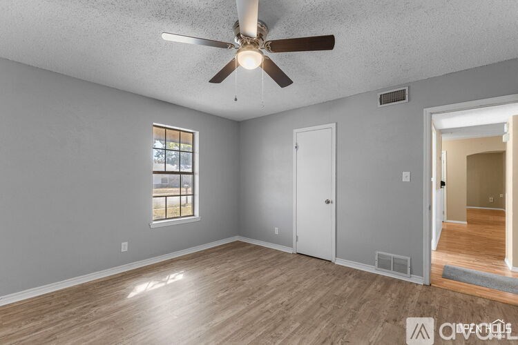 A room with a ceiling fan and a window.