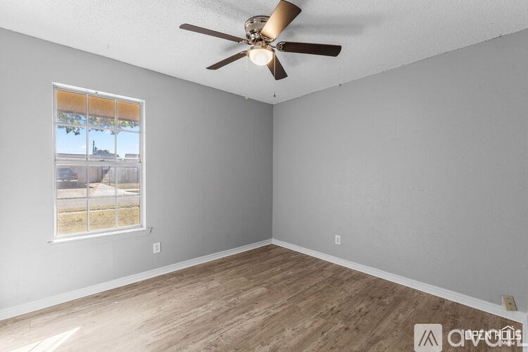 Empty room with a ceiling fan and a window.