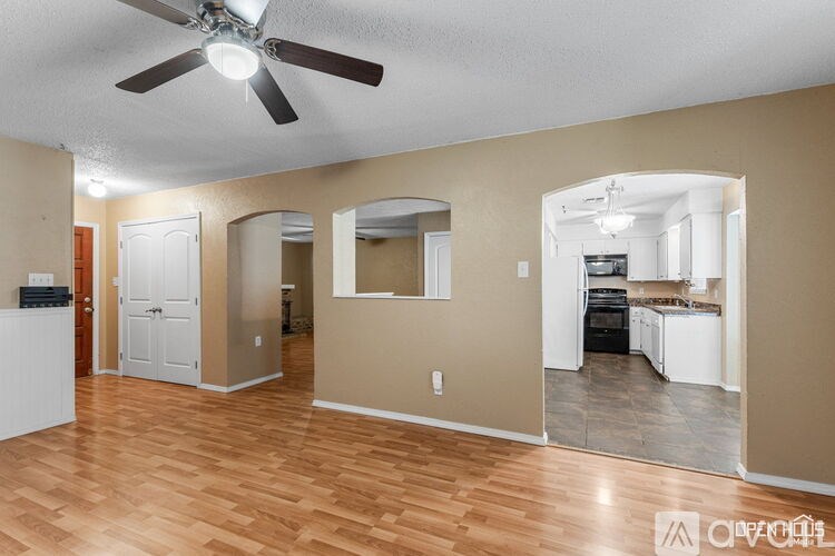 A room with a ceiling fan and a mirror on the wall.