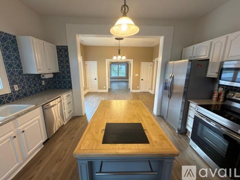 A kitchen with a wooden island in the middle.