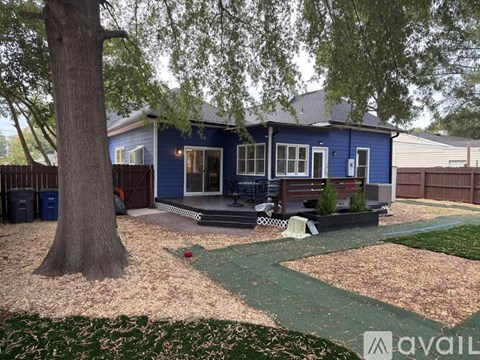 A blue house with a tree in front of it.