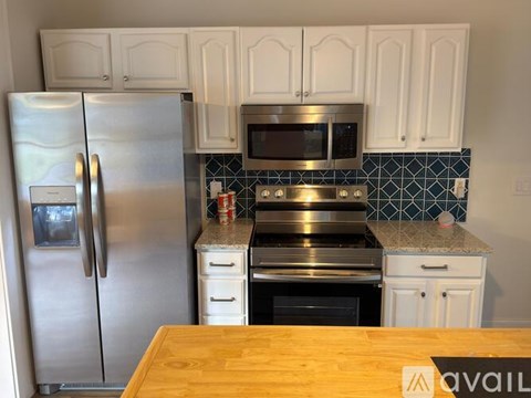 A kitchen with a stainless steel refrigerator, microwave, and oven.