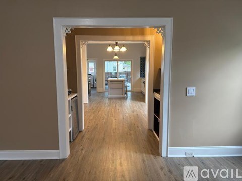 A hallway with a light fixture and a doorway leading to another room.