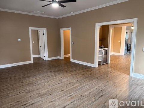 A room with wooden flooring and a ceiling fan.
