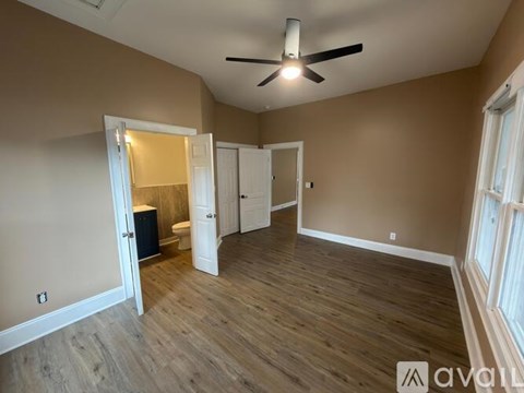 A room with a ceiling fan and wooden flooring.