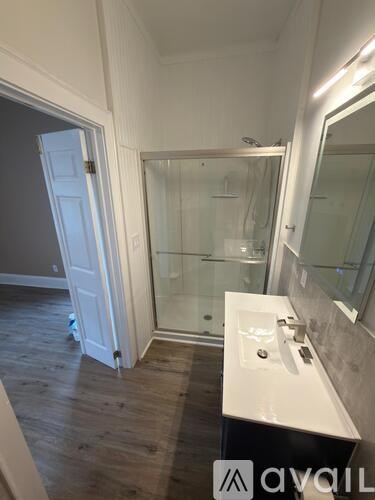 A bathroom with a white sink and a glass shower stall.