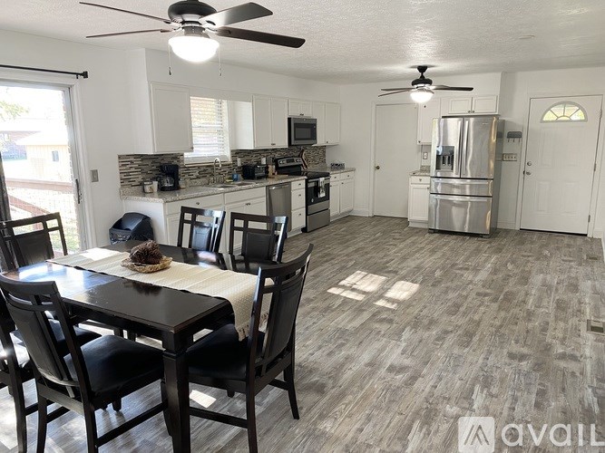 A kitchen with a dining table and chairs.