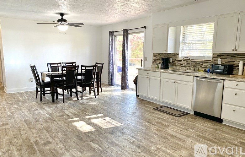 A kitchen with a dining table and chairs in the middle of the room.