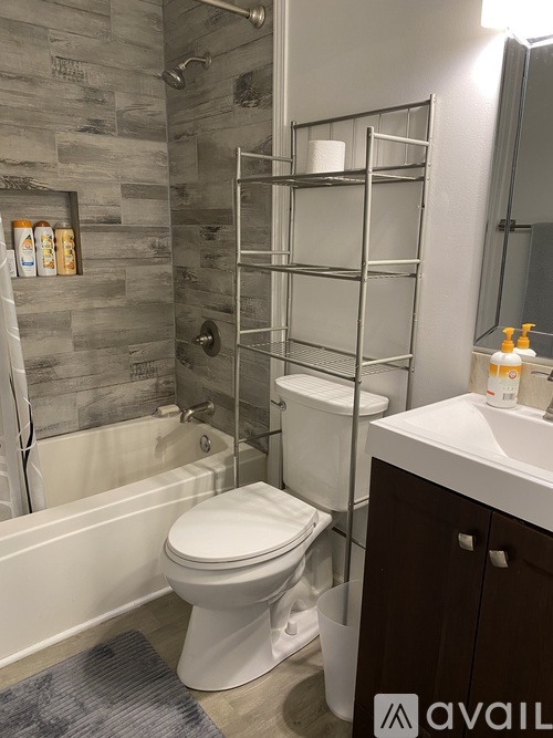 A bathroom with a toilet, sink, and a shower with a glass door.