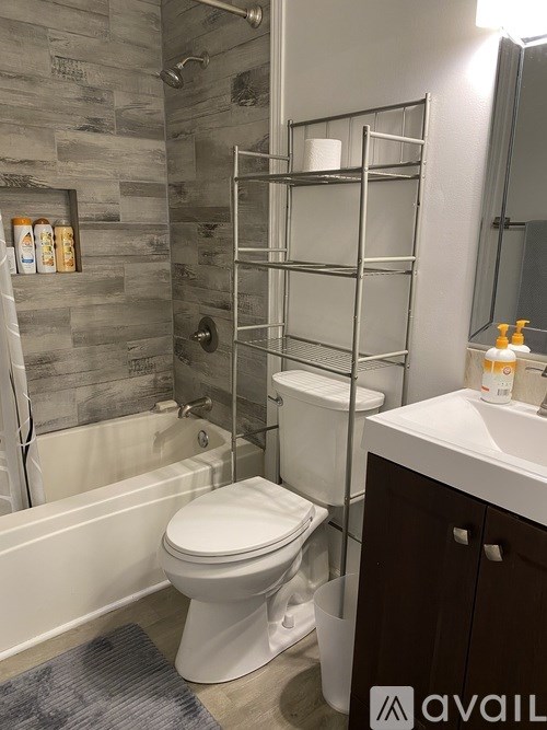 A bathroom with a toilet, sink, and a shower with a glass door.