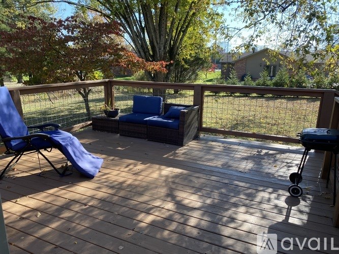 A wooden deck with a blue chair and a blue blanket.