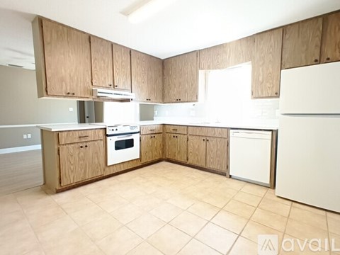 A kitchen with wooden cabinets and a white refrigerator.