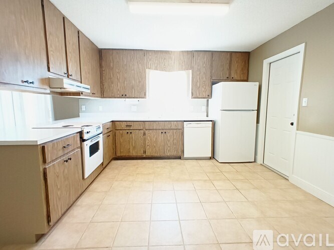 A kitchen with wooden cabinets and white appliances.
