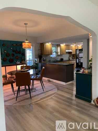 A kitchen with a dining table and chairs in the foreground.
