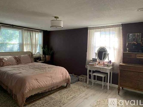 A bedroom with a bed, desk, and chair.